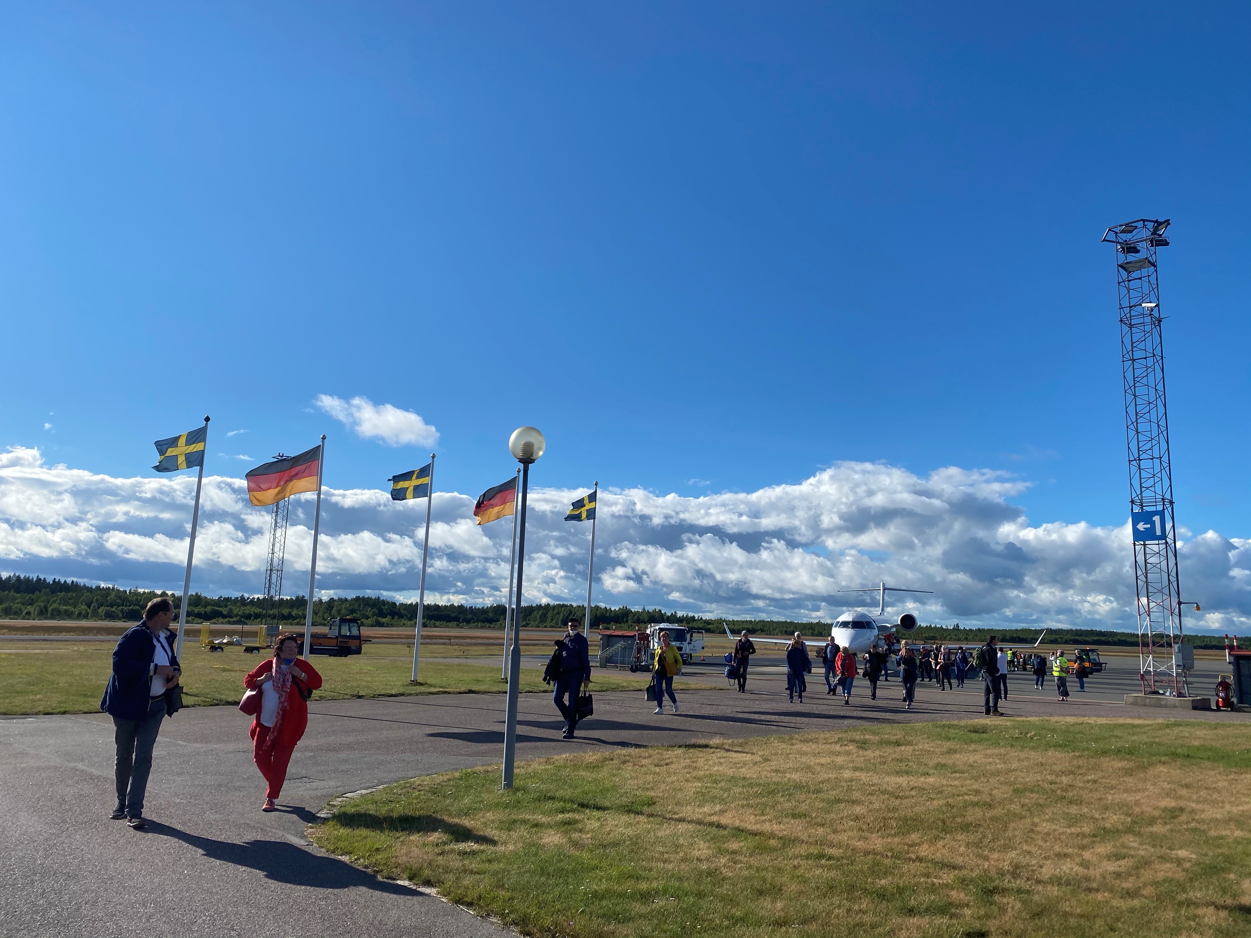 Resenärer från Tyskland kliver av planet i Jönköping och går mot flygplatsterminalen