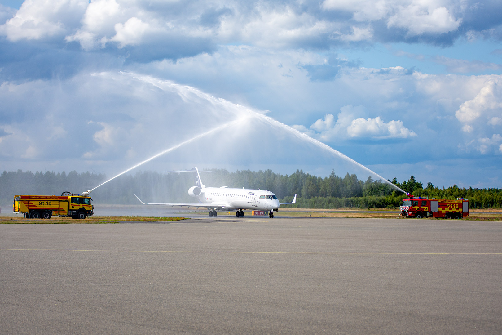 Ankommande flygplan välkomnas med vattensalut från flygplatsens brandbilar