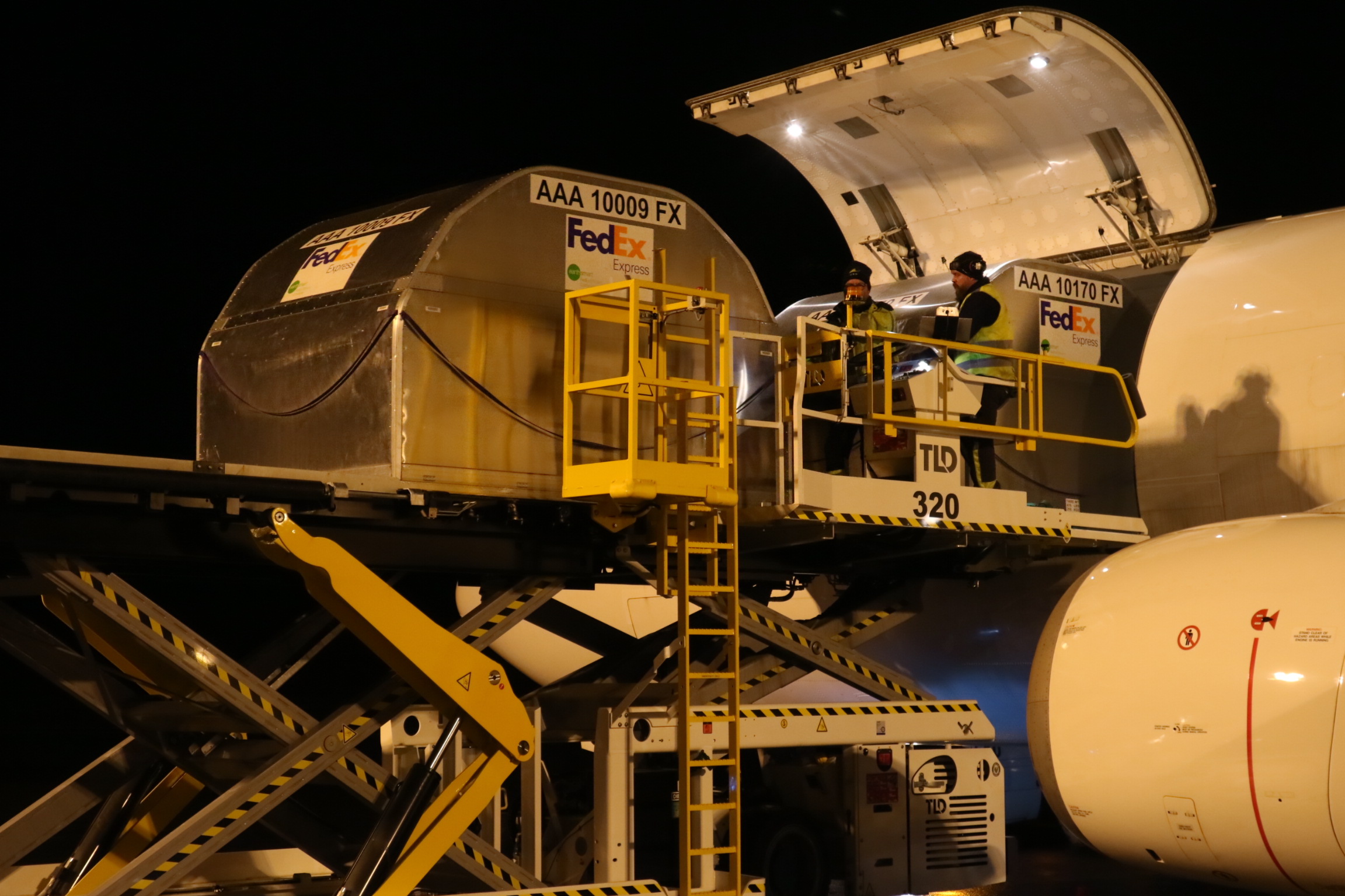 FeDex fraktflyg lossas av två medarbetare
