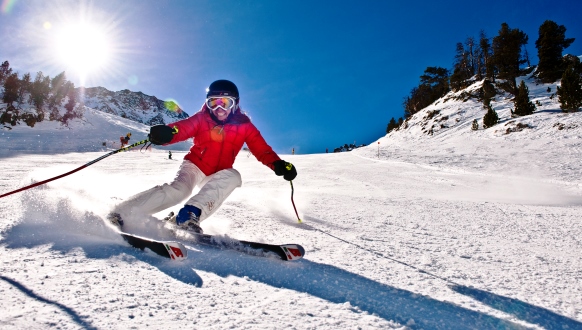 Skidåkare åker slalom i vitt backe och strålande sol i Andorra